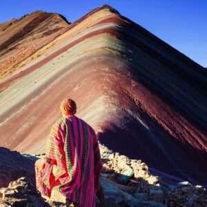 hombre contemplando la montaña de colores vinicunca en peru